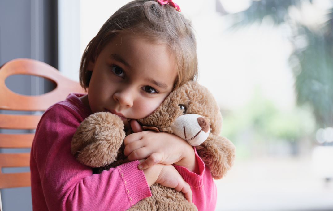 Girl cuddling teddy AM Day